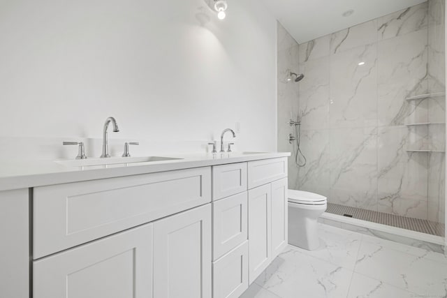 bathroom featuring a tile shower, vanity, and toilet