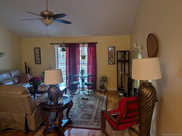 living area with lofted ceiling, ceiling fan, baseboards, and wood finished floors