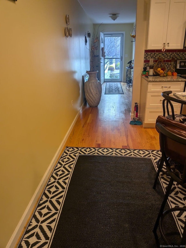 hall with light wood finished floors and baseboards