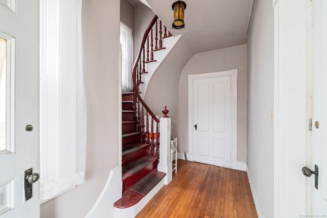 entrance foyer with stairs, baseboards, and wood finished floors