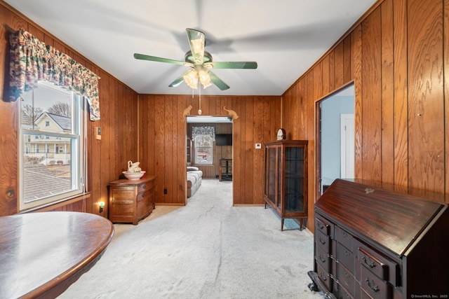 corridor featuring wooden walls and light colored carpet