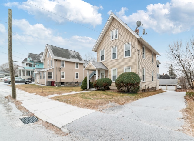 view of front of property with central AC, an outdoor structure, a residential view, a front lawn, and a chimney