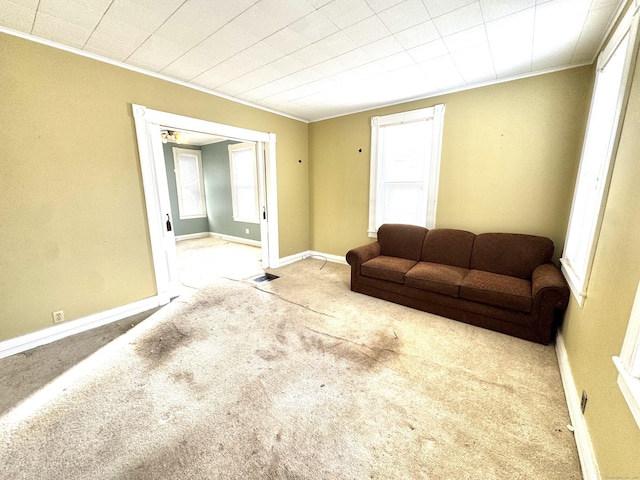 living room with light carpet, crown molding, and baseboards