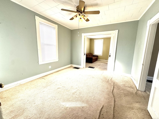 unfurnished bedroom with light carpet, crown molding, visible vents, and baseboards