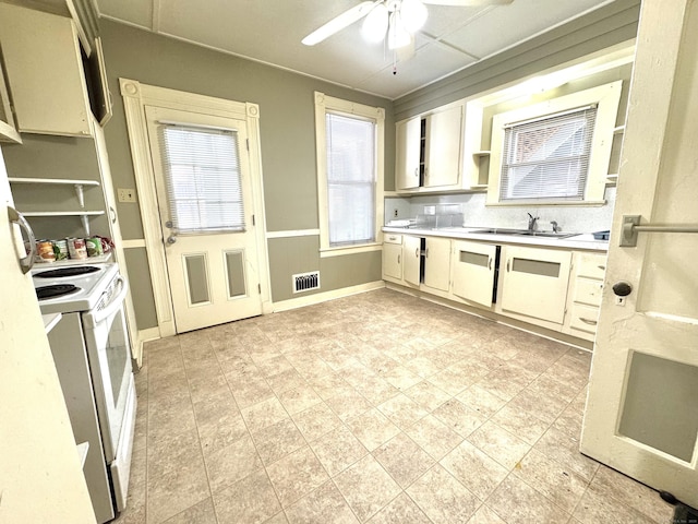 kitchen featuring white electric stove, light countertops, visible vents, a sink, and ceiling fan