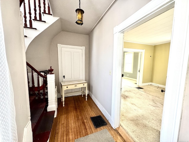 interior space with visible vents, stairway, baseboards, and wood finished floors