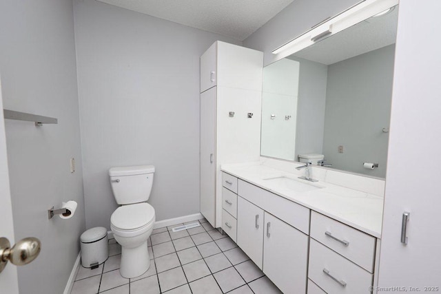 bathroom featuring tile patterned flooring, vanity, toilet, and a textured ceiling