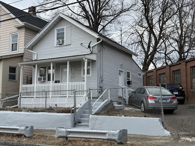 view of front facade featuring covered porch and cooling unit