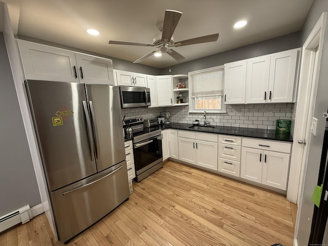 kitchen with white cabinets, appliances with stainless steel finishes, backsplash, and sink