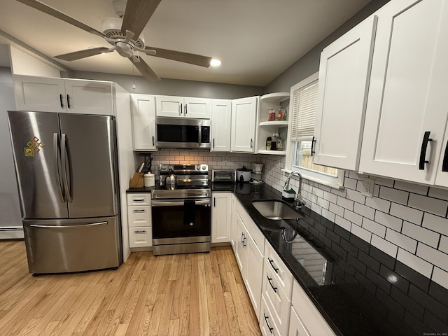 kitchen featuring sink, light wood-type flooring, appliances with stainless steel finishes, tasteful backsplash, and white cabinetry