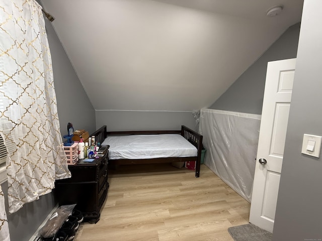 bedroom with light hardwood / wood-style flooring and vaulted ceiling