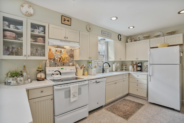 kitchen featuring cream cabinets, white appliances, and sink