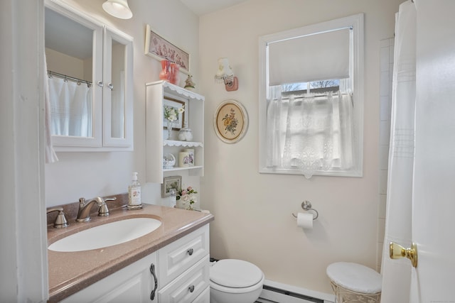 bathroom with vanity, toilet, and a baseboard heating unit