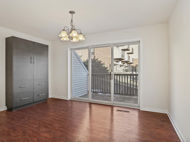 interior space featuring dark wood-type flooring and a chandelier