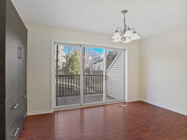 unfurnished dining area with a chandelier and dark hardwood / wood-style floors