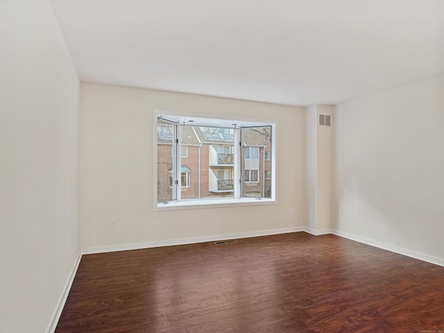 spare room featuring dark wood-type flooring