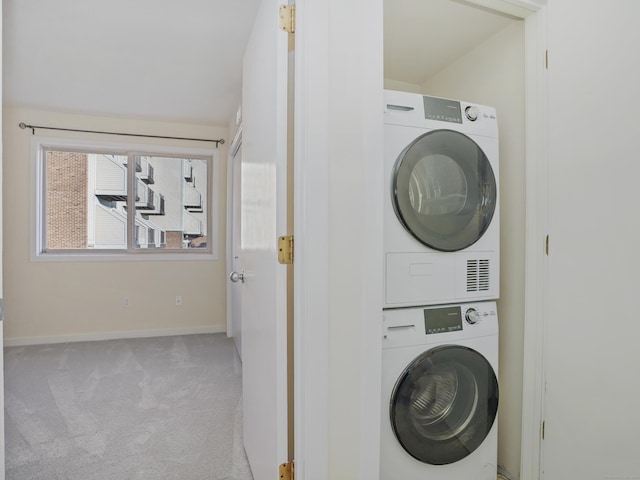 clothes washing area with light colored carpet and stacked washing maching and dryer