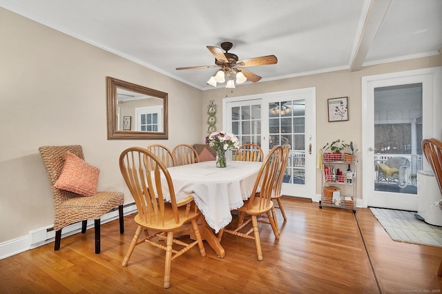 dining area with french doors, ceiling fan, a baseboard heating unit, crown molding, and hardwood / wood-style floors