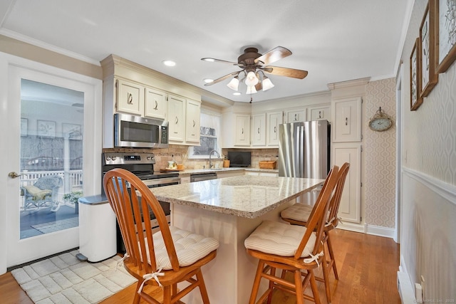 kitchen with a center island, backsplash, light wood-type flooring, light stone counters, and stainless steel appliances