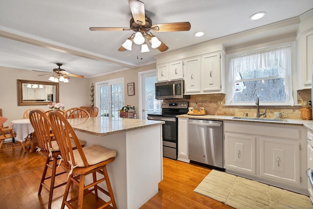 kitchen featuring white cabinetry, sink, ornamental molding, and stainless steel appliances