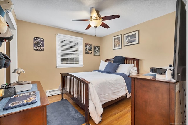 bedroom with hardwood / wood-style flooring, ceiling fan, and a textured ceiling