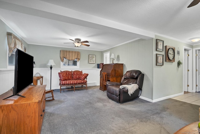 living room with ceiling fan, crown molding, carpet, and a textured ceiling