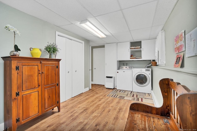 laundry area featuring cabinets, light wood-type flooring, and independent washer and dryer