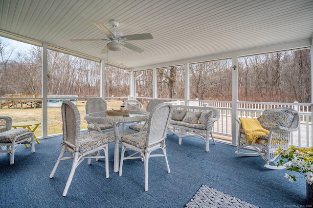 unfurnished sunroom featuring ceiling fan