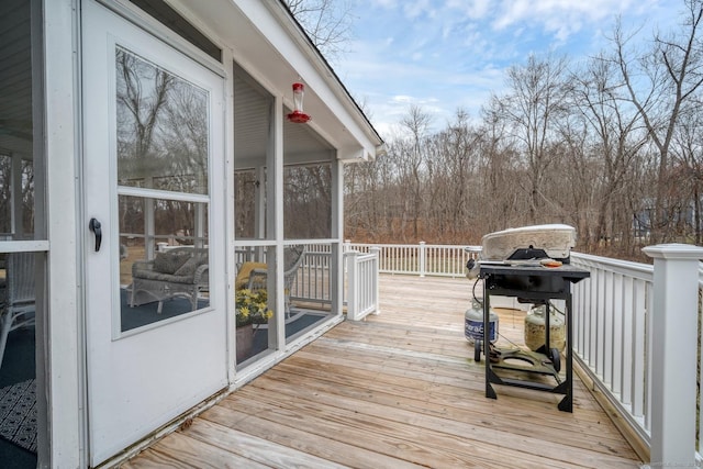 wooden deck with area for grilling and a sunroom