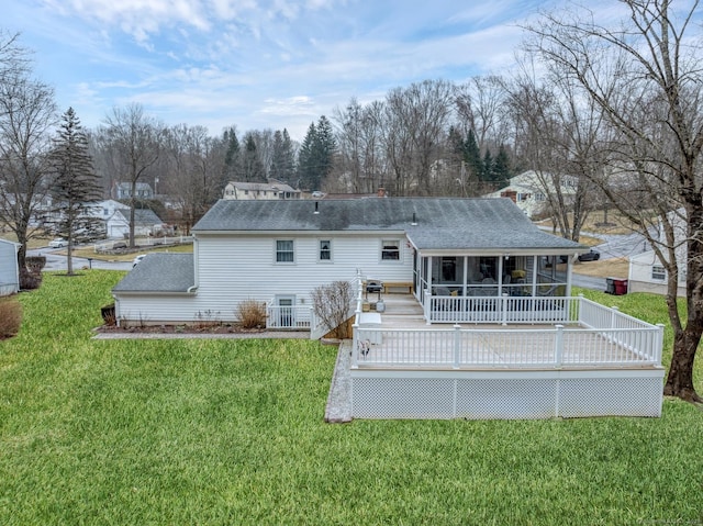 back of house with a lawn, a wooden deck, and a sunroom