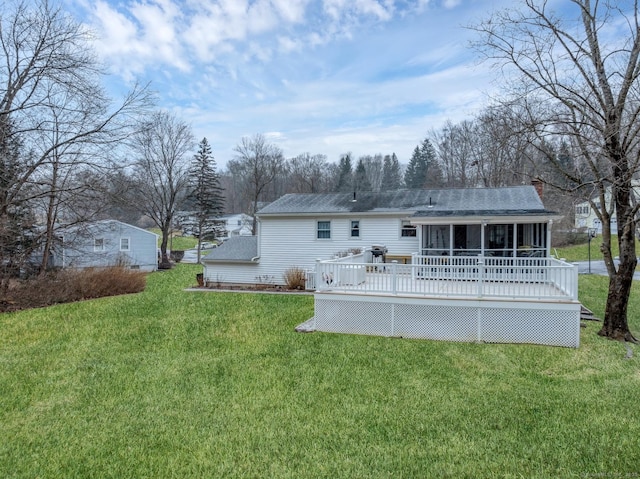 back of house with a lawn, a wooden deck, and a sunroom