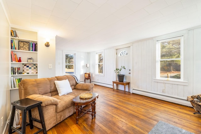 living room featuring hardwood / wood-style floors, plenty of natural light, and a baseboard heating unit