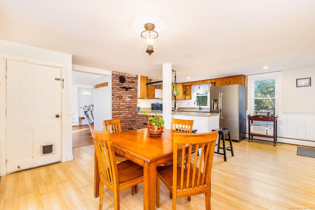 dining area with light wood-type flooring and sink