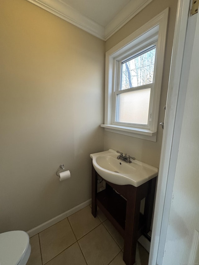 bathroom with tile patterned floors, vanity, toilet, and crown molding