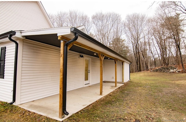 view of side of home featuring a patio area and a yard