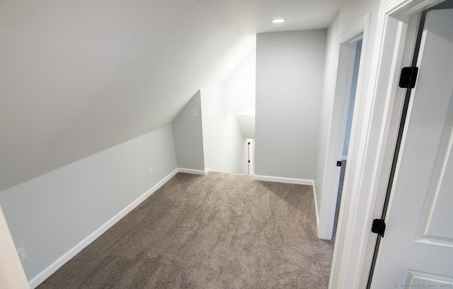 additional living space featuring carpet floors and vaulted ceiling