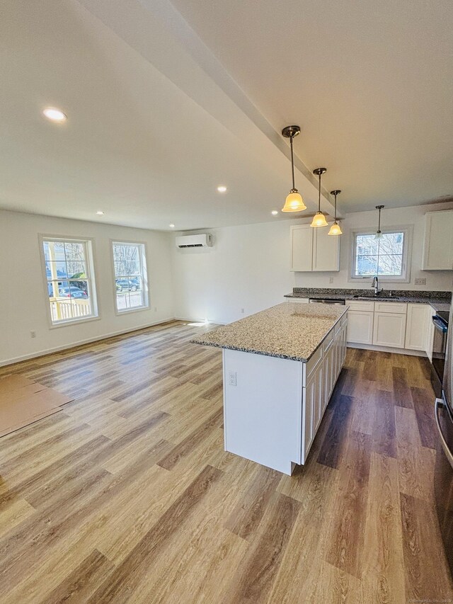 16 Red Bridge Rd, Thompson, CT 06255 - kitchen featuring a wall mounted AC, wood finished floors, healthy amount of natural light, recessed lighting, and white cabinets