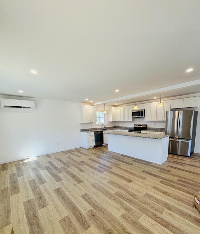 16 Red Bridge Rd, Thompson, CT 06255 - kitchen featuring stainless steel appliances, an AC wall unit, light wood finished floors, recessed lighting, and a center island