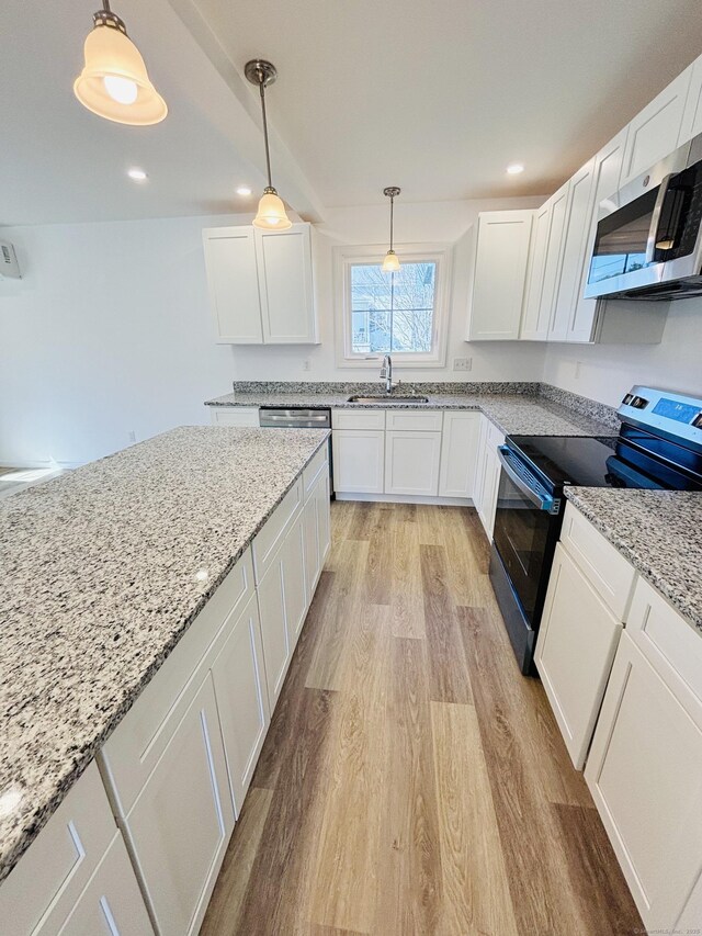16 Red Bridge Rd, Thompson, CT 06255 - kitchen featuring stainless steel microwave, electric range, light wood-style flooring, a sink, and white cabinetry