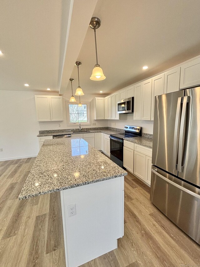 16 Red Bridge Rd, Thompson, CT 06255 - kitchen featuring stainless steel appliances, light wood-style floors, a sink, a kitchen island, and white cabinetry