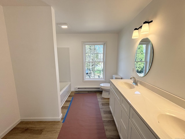 16 Red Bridge Rd, Thompson, CT 06255 - bathroom with a baseboard heating unit, toilet, plenty of natural light, and wood finished floors