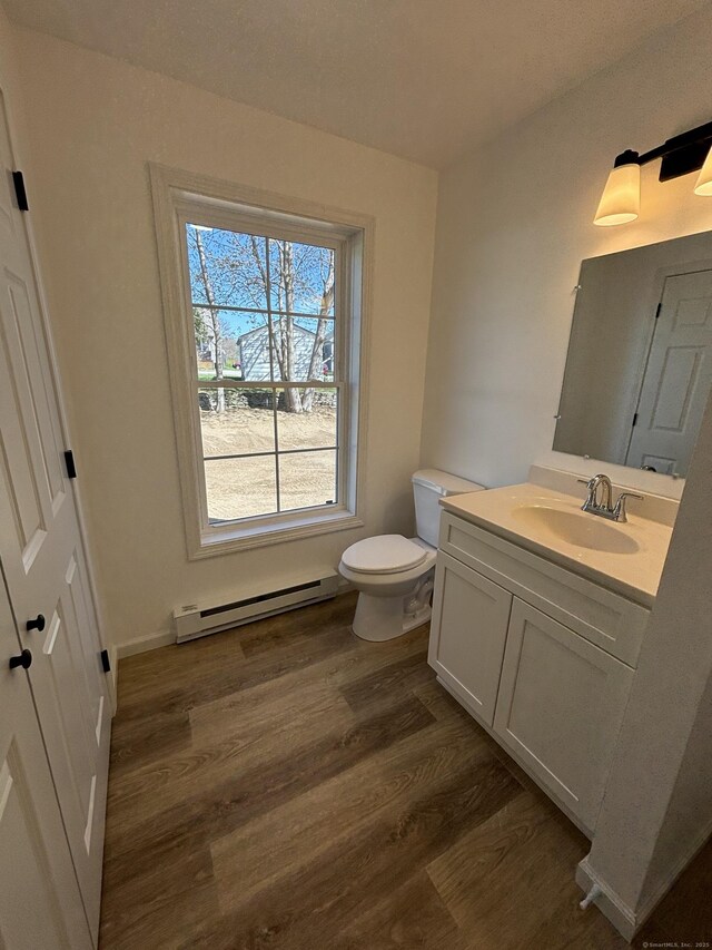 16 Red Bridge Rd, Thompson, CT 06255 - bathroom featuring a baseboard radiator, vanity, wood finished floors, and toilet