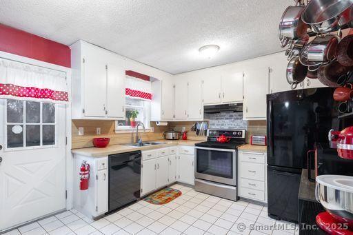 kitchen with white cabinetry, sink, a textured ceiling, decorative backsplash, and black appliances