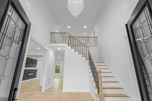 entrance foyer with a chandelier, light hardwood / wood-style flooring, and crown molding