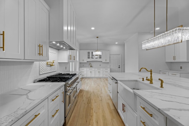 kitchen with light stone counters, white cabinets, pendant lighting, and range with two ovens