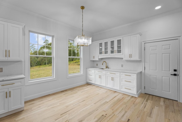 kitchen featuring white cabinets, tasteful backsplash, a healthy amount of sunlight, and sink