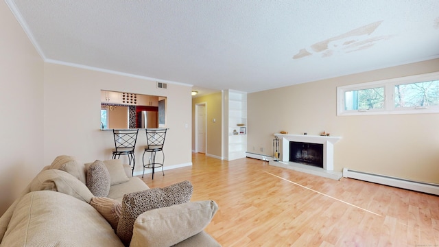 living room featuring a textured ceiling, wood-type flooring, ornamental molding, and a baseboard heating unit