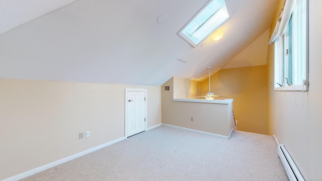 bonus room with light colored carpet, lofted ceiling with skylight, baseboard heating, and ceiling fan