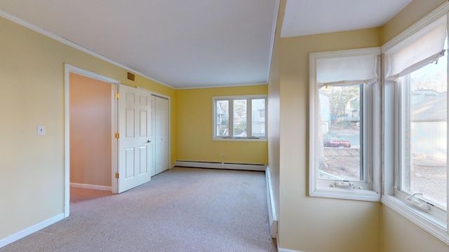 empty room featuring crown molding, light colored carpet, and a baseboard radiator