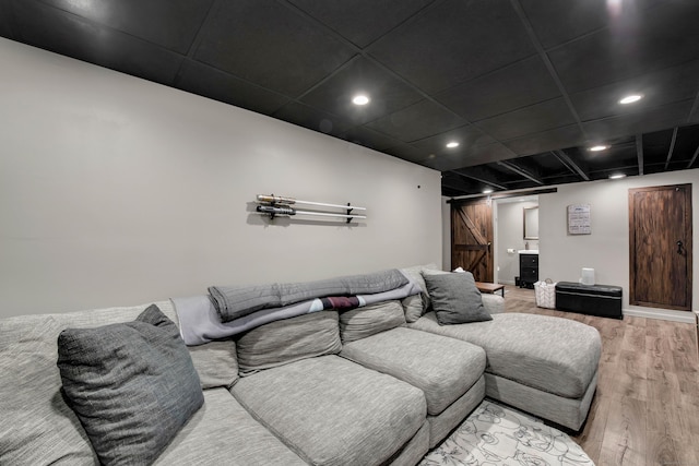 cinema with a barn door and light hardwood / wood-style floors